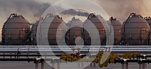 Pipelines and fuel tanks in the fuel warehouse in the light of the setting sun against the background of the refineries