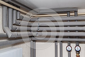 The pipelines in the insulation and pressure gauges flow and return pipes in the boiler room of a private house