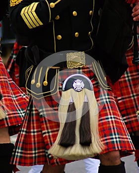 Piper Sporrann on a plaid kilt with black tunic