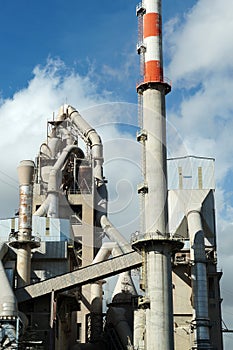 pipes of a cement plant against the background of a cloudy sky close-up