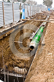 Pipes with heat isolation lieing in the trench. photo