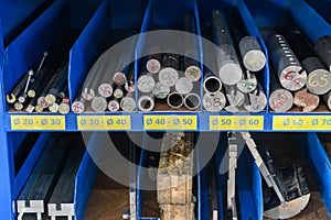 pipes, metal pieces and various metal parts for a CNC machine standing on a shelf