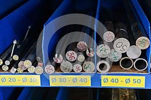 pipes, metal pieces and various metal parts for a CNC machine standing on a shelf