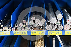 pipes, metal pieces and various metal parts for a CNC machine standing on a shelf