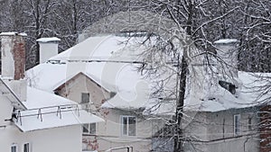 pipes on the roofs of houses in a snowfall on a winter day