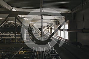 Pipes of ventilation system under ceiling in factory, industrial background