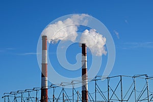 Pipes with white smoke. Industrial landscape. Smoke pollutes environment. Ecology problems