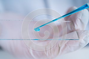 Pipette adding fluid to one of several test tubes .medical glassware.