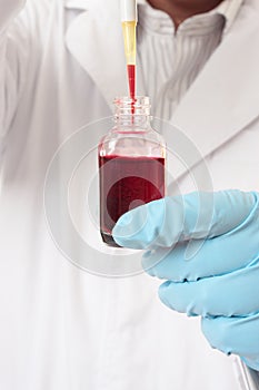Pipette aspirating liquid from bottle photo