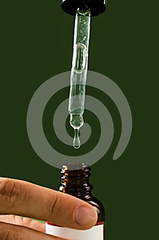 Pipette with Cannabidiol CBD oil in hand close-up. CBD oil from the Cannabis plant to help reduce pain, anxiety, and