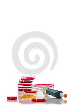 Pipette and petri dish with red liquid, on white, background