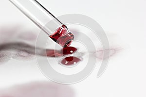 pipette with wine drops on white sheet with stains