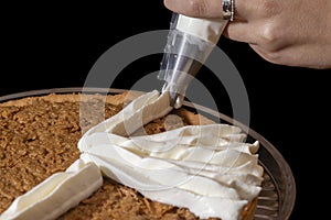 Piping chantilly cream onto a tart