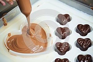 piping chocolate into heartshaped molds