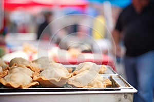 piping hot empanadas displayed at a street fair