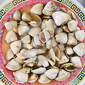 Pipis seafood in oriental style round plate.