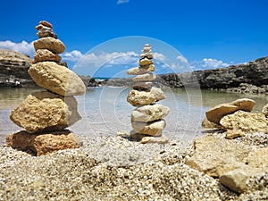 Piramide stack of zen stones near sea and blue sky