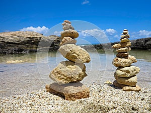 Piramide stack of zen stones near sea and blue sky