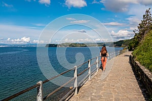Piran - Tourist woman on scenic walking path between Fiesa and charming coastal town of Piran