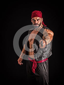 The Pirate, A Male Bodybuilder with a Red Bandanna Standing Proudly Before a Black Canvas