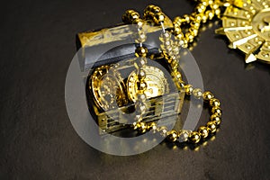 Pirate medal, chest with gold coins on a black background