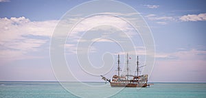 Pirate ship at the open sea at the sunset