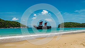 Pirate ship sailing in the Ocean. Cruise boat with tourists on the sea during vacation.