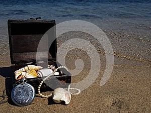 a pirate treasure chest on a sandy beach.a treasure trove of seashells, antique watches and jewelry found