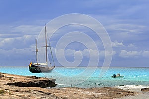 Pirates inspired wood sailboat anchored turquoise