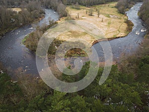 The Pirita River flows through the forest in spring day, photo from a drone in cloudy weather. Nature of Estonia photo