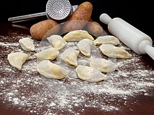 Pirogues, pierogi , Ukrainian food, on wooden table with rolling pin. photo