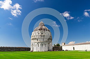 Pisa Baptistery Battistero di Pisa on Piazza del Miracoli Duomo square green grass lawn, city wall, Camposanto cemetery