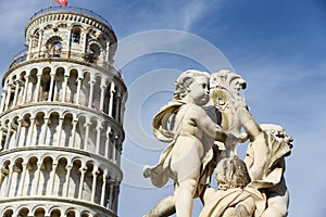 Pisa, Italy. September 16, 2023. Roman statues and vases with the leaning tower of Pisa in the background