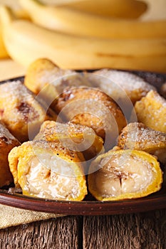 Pisang goreng fried bananas in batter on a plate macro. vertical