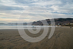 Pismo State Beach, California. Seashore, mountains, Pacific ocean, and cloudy sky on background