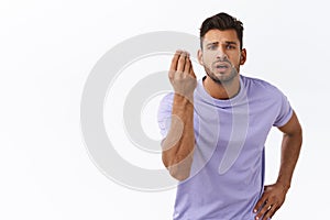 Pissed sexy guy with beard in purple t-shirt shaking fingers in italian gesture, where is my money or what do you want