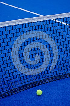 Pista de paddle tennis. Una pelota aislada cerca de la red