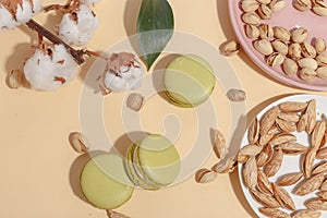 Pistachio cake makaroons and forex pistachios on a beige background. Top view