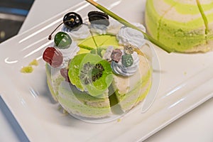 Pistachio cake sliced on white wooden background