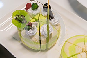 Pistachio cake sliced on white wooden background