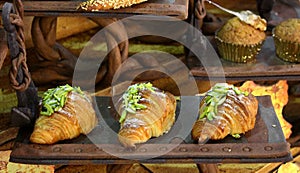 Pistachio flavored croissant displayed in rustic way photo