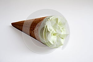 Pistachio ice cream cone on white background