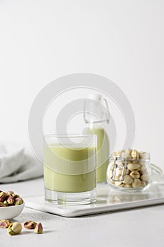 Pistachio milk in glass, lactose free. Vegan nutty plant based milk.