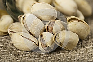 Pistachio nuts arranged on a burlap cloth. A tasty snack consumed with beer