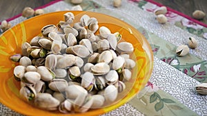 Pistachio nuts falling into bowl, slow motion