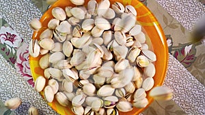 Pistachio nuts falling into bowl, slow motion