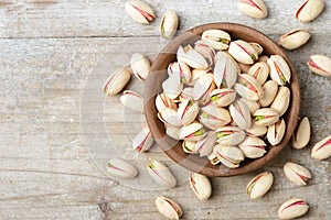 Pistachio nuts with shell on the wooden board, top view