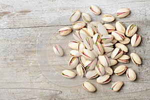 Pistachio nuts with shell on the wooden board, top view