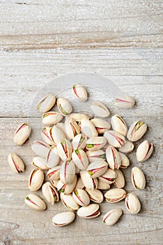 Pistachio nuts with shell on the wooden board, top view