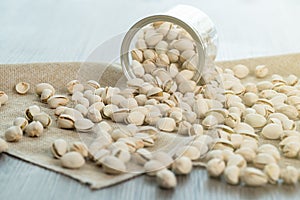 Pistachio nuts in transparent glass jar on a wooden table. Healthy food high protein